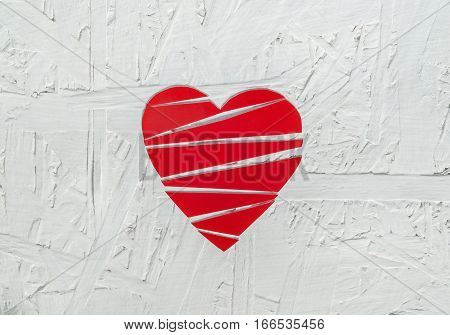 Close up of paper broken heart on white wooden background