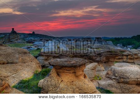 Golden sunrise over the Hoodoo badlands at Writing on Stone Provincial Park and Aisinaipi National Historic Site in Alberta Canada. The area contains the largest concentration of First Nation petroglyphs (rock carvings) and pictographs (rock paintings).