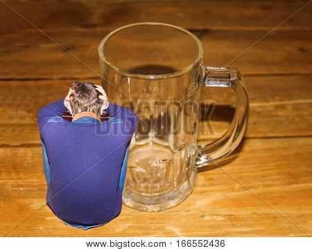 Portrait of empty beer glass and depressed man. Concept of youth addicted to alcohol, alcoholism, social problem