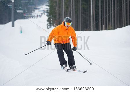 Skier Skiing Downhill At Ski Resort Against Ski-lift