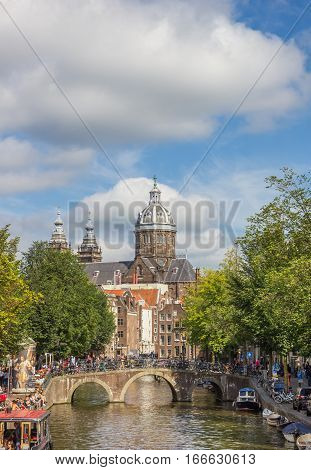 AMSTERDAM, NETHERLANDS - SEPTEMBER 18, 2016: Canal bridge and the St. Nicolas church in Amsterdam, Holland