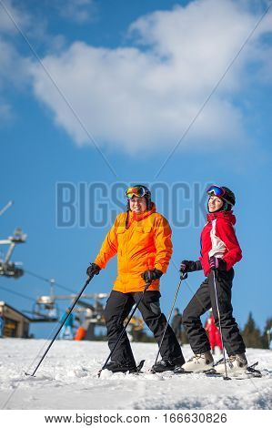 Man And Woman Skiers With Skis At Winter Resort