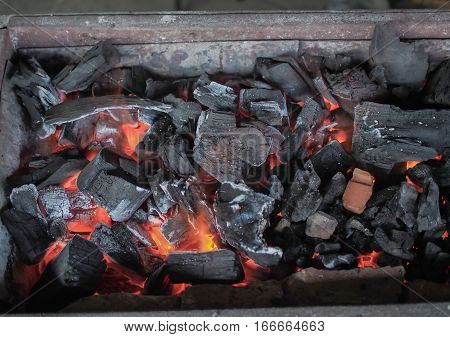 Hot Burning coal fire with red and white ash close-up