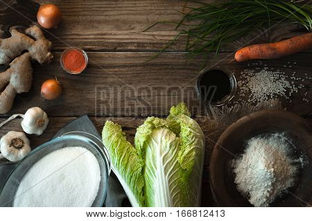 Frame with Chinese cabbage and ingredients for kimchi on a wooden table horizontal