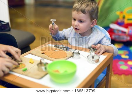 Creative young cute kid playing with playdough