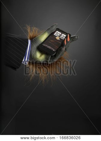 Hairy hand holding cell phone against grey graduated background