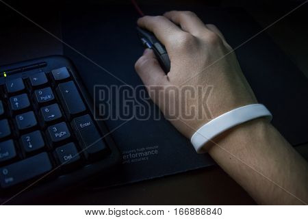 Male hand with bracelet holding computer mouse