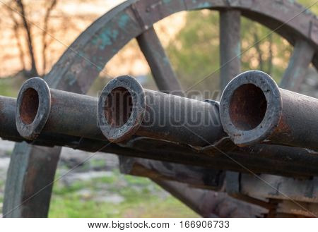 Vintage multi barrelled cannon - ribaudequin. Gun barrel close-up. Focus on the center of the frame