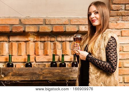 Woman Tasting Wine In Rural Cottage Interior