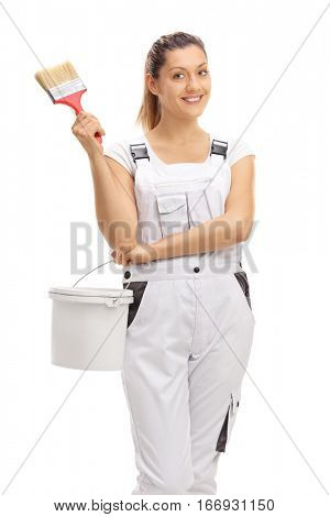 Happy female decorator holding a paintbrush and a color bucket isolated on white background