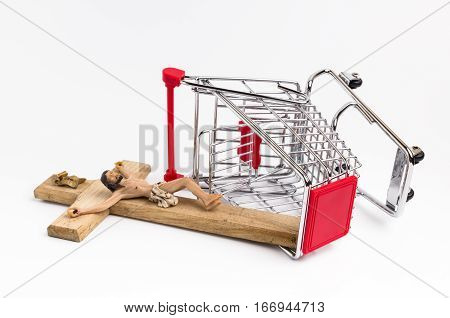 Shopping cart overturned with crucifix on the ground. Conceptual representation of commodification of religion loss of faith blasphemy.