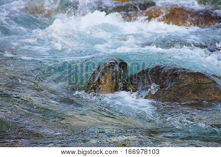 Stormy River: Waves crashing against a rock.