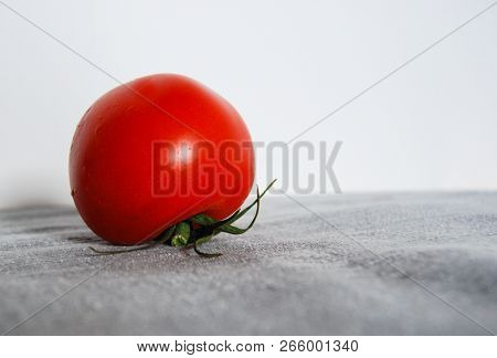 Close-up Of One Red Tomato And Ripe With Freshly Picked Petiole After Washing
