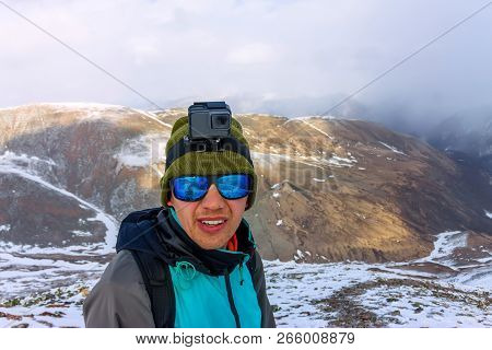 Portrait Male Mountaineer In Snowy Mountains, With A Backpack