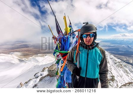 Portrait Man Mountaineer In Snowy Mountains, Wearing A Helmet