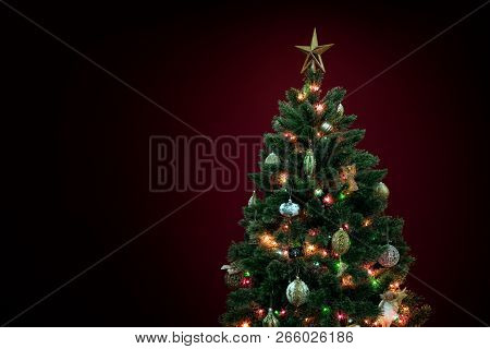 View Of Nice Decorated Christmas Tree On Deep Red Back