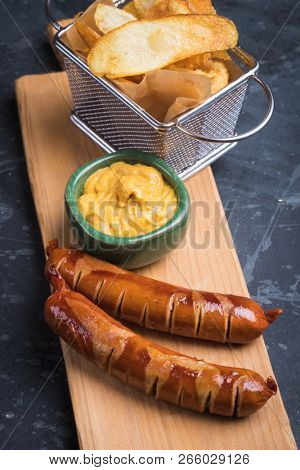 Grilled german sausaged with mustard and frued tomato chips