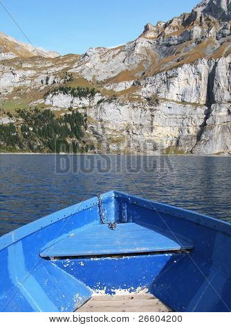 Příď lodi proti povrchu Oeschinensee jezero a Alpy