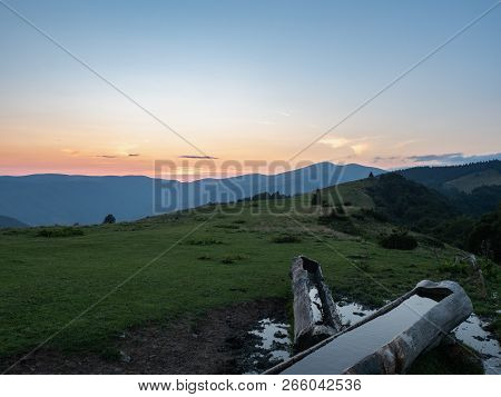 Wooden Warertrough On Mountain Pasture. Carpathians Mountains, West Ukraine. Ukrainian Nature Backgr