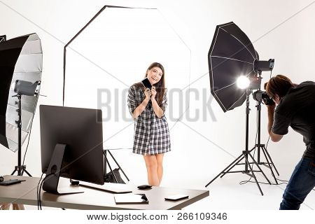 Photographer And Model Working In Modern Lighting Studio With Many Kinds Of Flash And Accessories.