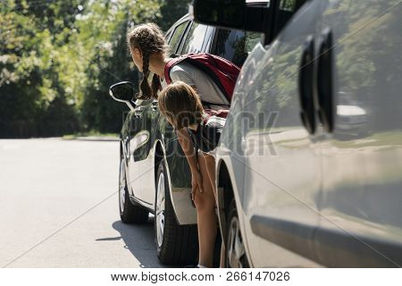Children Walking Through The Road Between Cars. Dangerous Passage