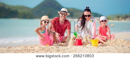 Family Making Sand Castle At Tropical Beach