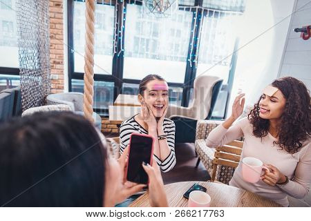 Positive Delighted Women Taking Photos Of Each Other