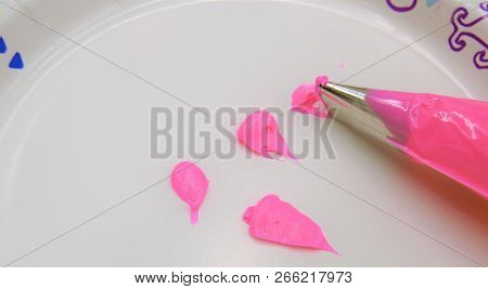 Pink Icing In Plastic Piping Bag With Decorative Tip