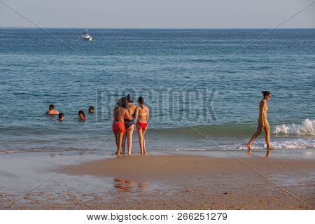 VILA DO BISPO, PORTUGAL - AUGUST 21, 2018: People at the famous beach of Salema in Vila do Bispo. This beach is a part of famous tourist region of Algarve.