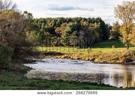 Horizontal Landscape With A Stream Running Though With Autumn Trees And Blue Skies Near Howick, Queb
