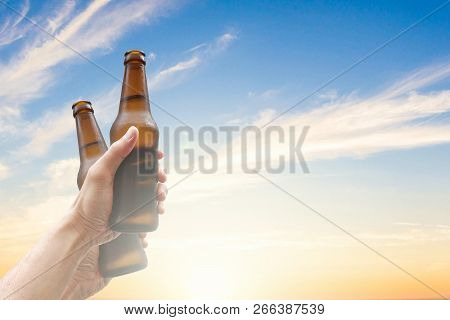 Hands Holding Two Beer Bottles And Happy Enjoying Harvest Time Together To Clinking Glasses At Outdo