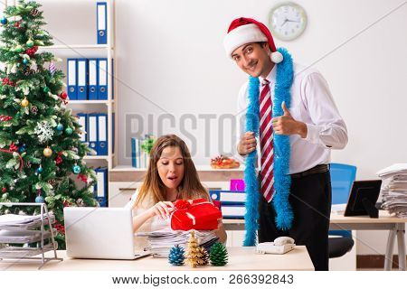 Colleagues exchaing christmas presents in office