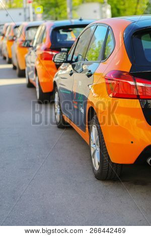 MOSCOW - MAY 8, 2018: Back of five black and orange BMW cars are on asphalt on sunny street for carsharing, Moscow carsharing company You drive
