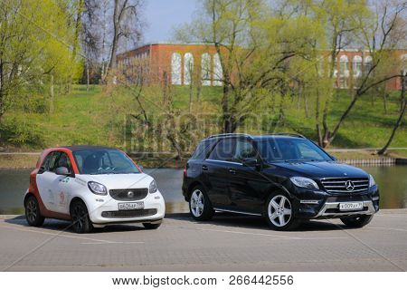 MOSCOW - APR 30, 2018: Black Mercedes Benz car and white Mercedes Smmart car of Moscow carsharing company You drive are near pond, carsharing is system of short-term car rental