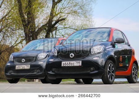 MOSCOW - APR 30, 2018: Two Mercedes Benz Smart cars of Moscow carsharing company You drive in spring park, carsharing is system of short-term car rental