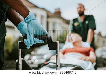 Paramedics moving a patient on a stretcher to an ambulance