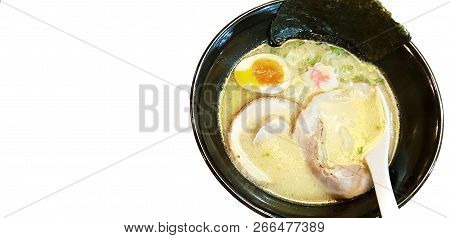 Japanese Food Style, Top View Of Ramen With Pork, Egg, Miso Based Soup, Spoon In Black Bowl Isolated