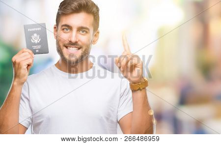 Young handsome man holding passport of united states over isolated background surprised with an idea or question pointing finger with happy face, number one