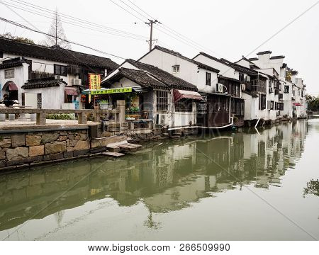Suzhou, China - March 23, 2016: Water Canal In Suzhou Old Town Lined With White Walled Houses At The