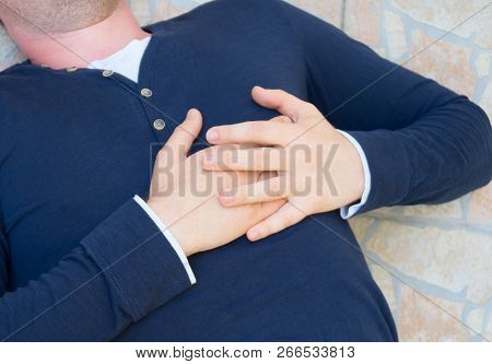 Man With A Heart Attack Lies On The Ground.
