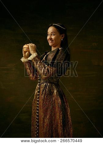 Girl In Medieval Beautiful Dress Or Costume Of The Countess At Dark Studio.