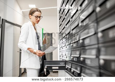 Dispirited Woman Checking Bills Getting Correspondence From The Mailboxes In The Walk Hall Of The Re