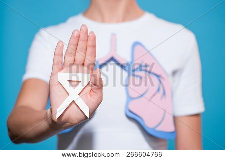 Partial View Of Woman With Paper Made Lungs Showing Lung Cancer Awareness White Ribbon On Blue Backd