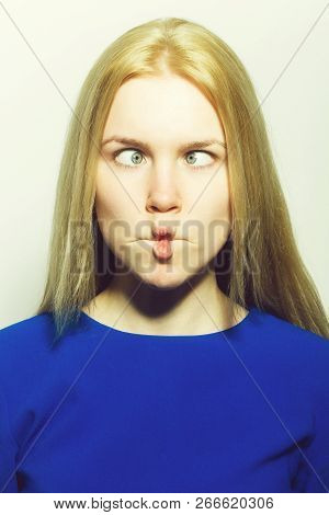 Woman Squinting Eyes On Funny Face. Young Woman With Crossed Grey Eyes, Healthy Skin And Long Blond 