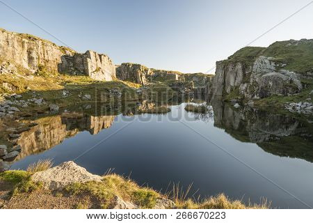 Beautiful Landscape Sunset Image Over Abandoned Foggintor Quarry In Dartmoor With Raking Soft Sunlig