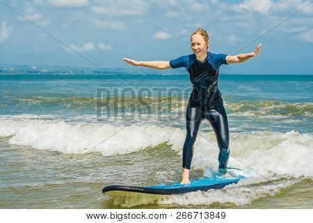 Joyful Young Woman Beginner Surfer With Blue Surf Has Fun On Small Sea Waves. Active Family Lifestyl