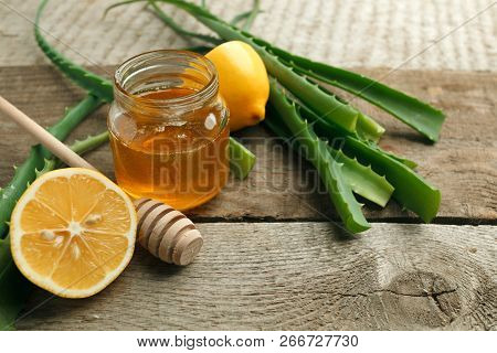 Honey In A Glass Jar, Lemon And Aloe Vera On Vintage Wooden Background. Alternative Medicine Closeup