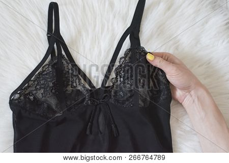 Fashionable Concept. Black Lace Pyjama Vest And Femalehand On White Fur.
