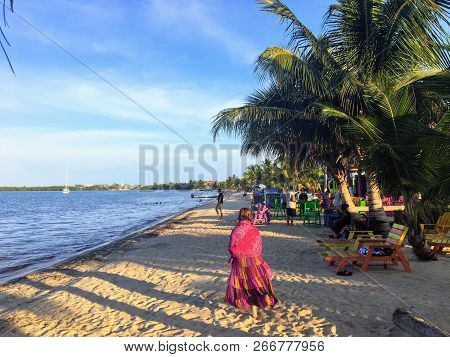 Placencia, Belize - May 26th, 2018: A Young Female Vacationer Goes For A Peaceful Stroll Along The S