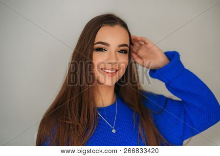Portrait Of The Young Beautiful Smiling Woman Inside. Girl In Bkue Sweater. Fashion Makeup